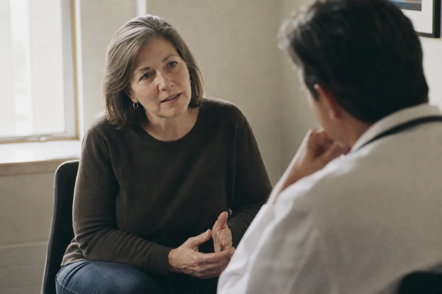 A patient in conversation with a doctor in a bright consultation room